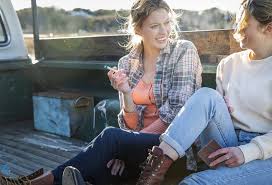 Two women enjoying a Sativa Pre-roll in the back of a pickup